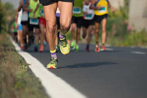 Group of people running on a paved road.
